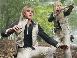 Ein Junge und eine Mädchen in Kampfposition im Wald