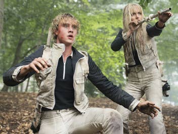 Ein Junge und eine Mädchen in Kampfposition im Wald