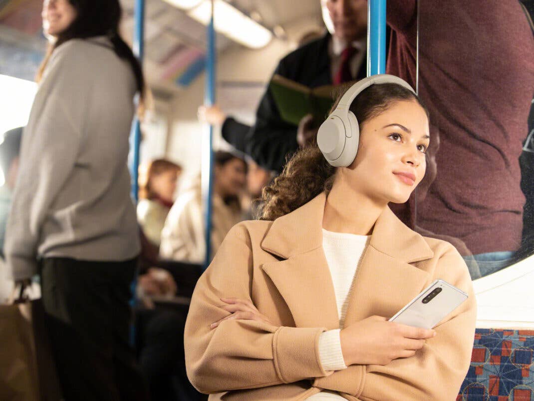 Eine Frau trägt die Sony Over-Ear-Kopfhörer WH-1000XM4