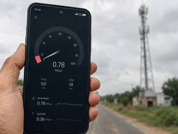 Ein Handy mit einem Speedtest, im Hintergrund ein Sendemast