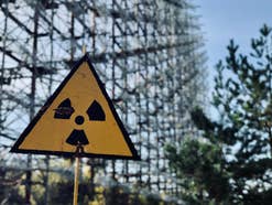 Ein Warnschild, das auf radioaktive Strahlung hinweist, in der Natur.