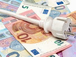 Stromkabel auf Euroscheinen Sinnbild für Stromkosten