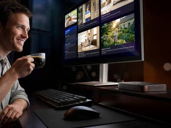 Mann sitzt vor einem Computer mit einer Tasse Kaffee