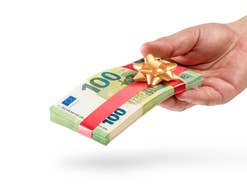 Tagesgeld: Allianz steigt ins Wettrennen um Top-Zinsen ein Hand überreicht ein Geldbündel