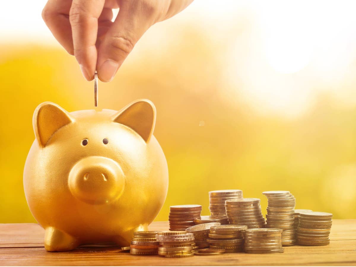 Tagesgeld: Die nächste beliebte Bank zahlt jetzt 2,0 Prozent Zinsen Hand steckt Geld in ein Sparschwein.