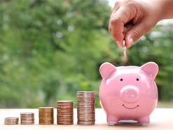 Tagesgeld: Nächste deutsche Großbank steigt mit Top-Angebot ein Hand steckt Münze in ein Sparschwein.