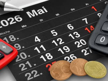 Ein Mai-Kalenderblatt, zwei Taschenrechner und 17 Cent in Münzen
