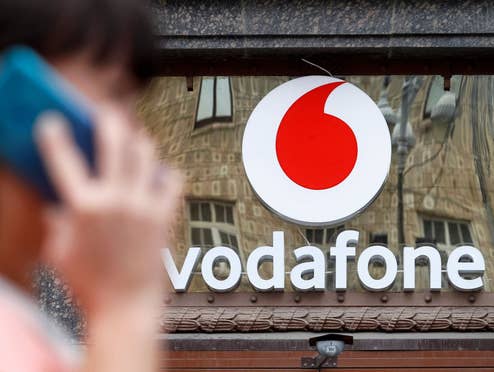 Frau telefoniert vor einem Vodafone-Store