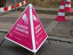 Ein Warnschild vor einer Glasfaser-Baugrube der Telekom