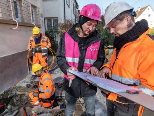 Deutschland baut Glasfaser, aber die Kunden zögern Bauarbeiter der Telekom vor einem Haus