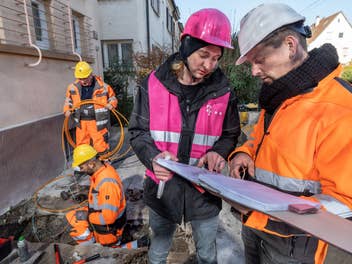 Bauarbeiter der Telekom vor einem Haus
