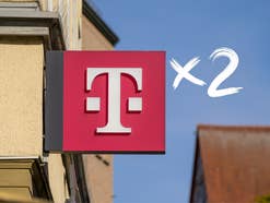 Telekom-Logo auf einem Schild an einer Wand, daneben ein Mal-Zwei-Symbol