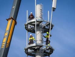 Techniker errichten einen Mobilfunkmast