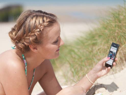 Eine Frau am Strand mit einem Handy