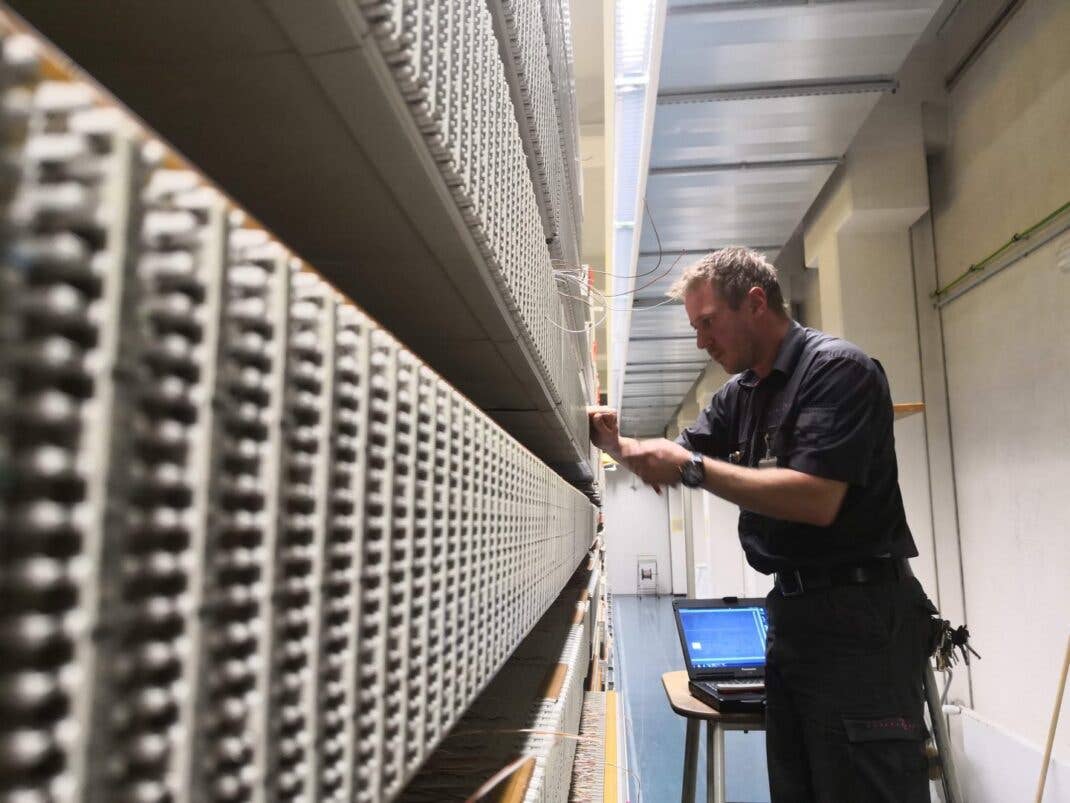 Ein Telekom-Techniker arbeitet in einer Vermittlungsstelle