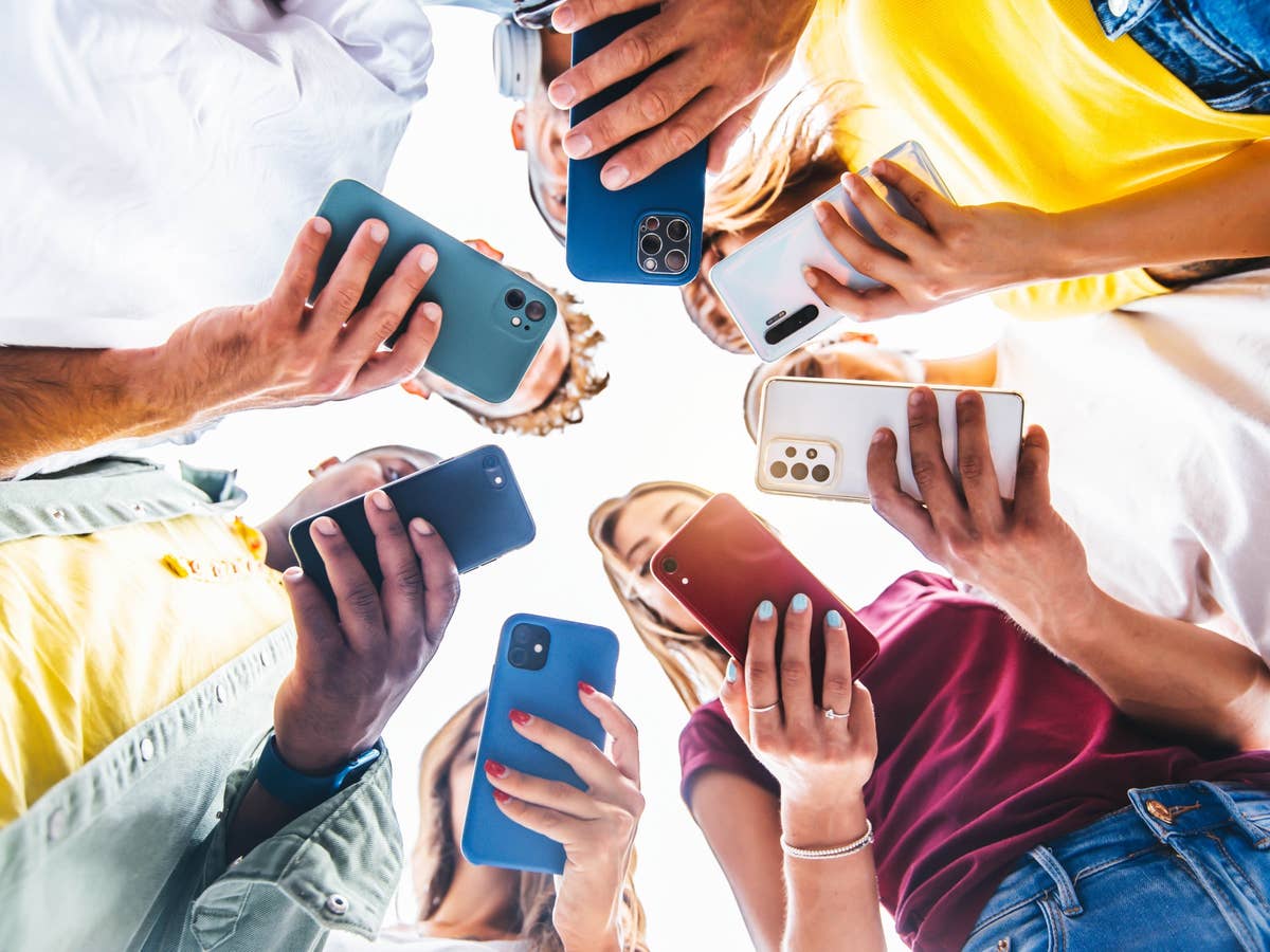 Jugendliche nutzen Smartphones in einem Kreis.