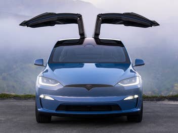 Tesla Model X mit geöffneten Flügeltüren.