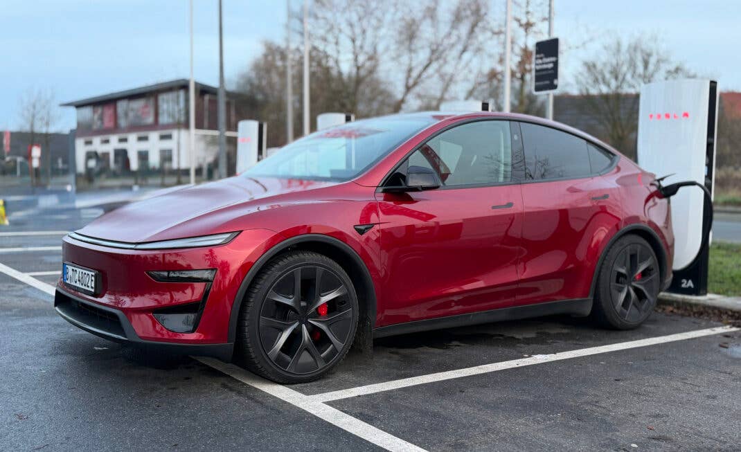 Tesla Model Y Performance AWD parkt an einem Supercharger.