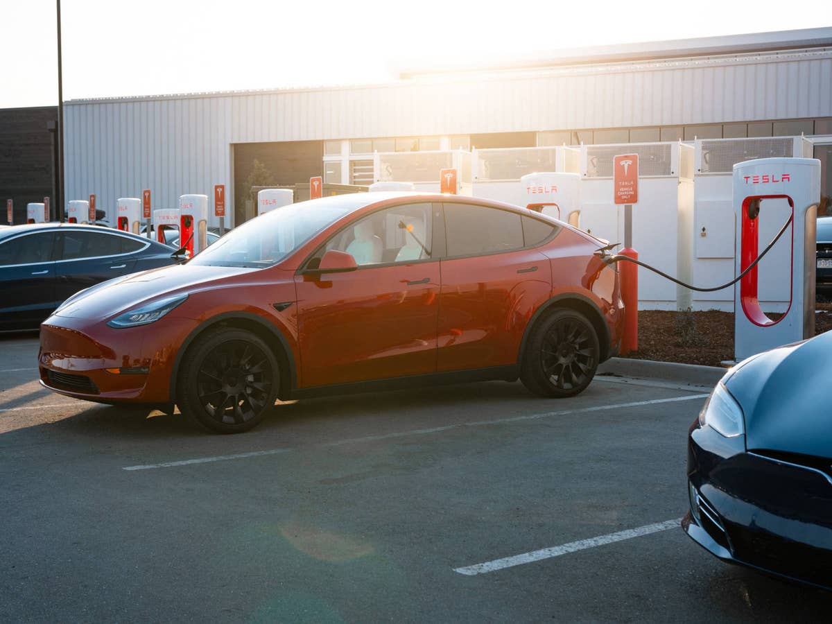 Tesla steht an einem Supercharger.
