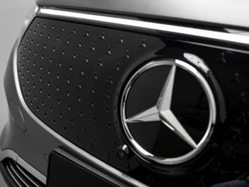 Mercedes Benz Stern an eimem Kühler eines Autos.