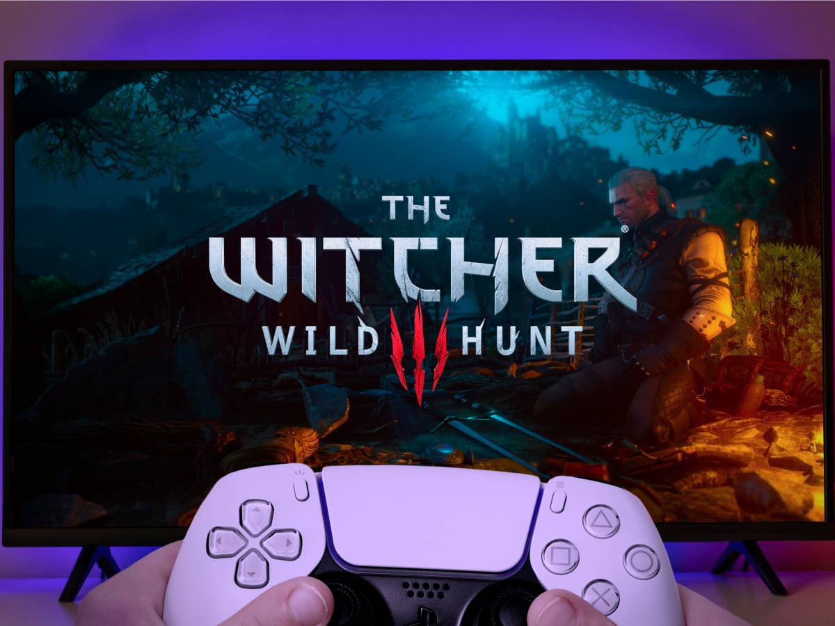 the-witcher-3-wild-hunt-ps5 Playstation Controller vor Fernsehbildschirm mit The Witcher 3: Wild Hunt als Startbildschirm