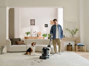 Ein Mann reinigt seinen Teppich mit dem Tineco Carpet One Cruiser