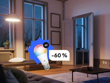 Eine Lampe beleuchtet ein Wohnzimmer - im Vordergrund sieht man eine smarte Glühbirne mit Rabatt.