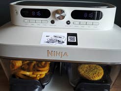 Der Ninja Crispi DualZone frontal mit Pommes und Gemüsepattie in den Glasbehältern