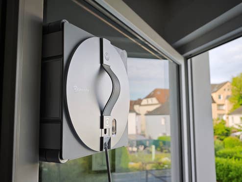 Der WINBOT W3 OMNI von ECOVACS wischt das Küchenfenster von außen.