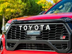 Toyota-Schriftzug an der Front eines Autos.