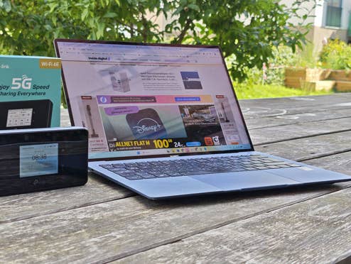 TP-Link M8550 steht auf einem Holztisch zusammen mit einem Laptop