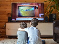 Zwei Jungen sehen sich Zeichentrickfilme im Fernsehen an