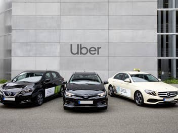 Drei parkende Autos: zweimal Uber und ein Taxi