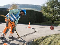 Glasfaser-Ausbau bei Unitymedia: Ein Bauarbeiter verlegt Speedpipes in der Straße