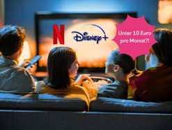 Eine Familie sitzt vor einem TV-Bildschirm.