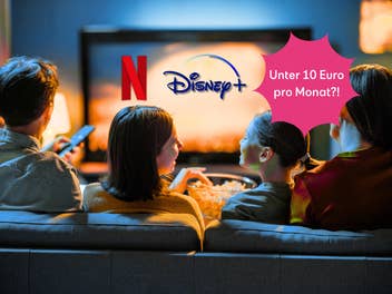 Eine Familie sitzt vor einem TV-Bildschirm.