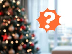 Ein Weihnachtsbaum verschwommen im Hintergrund. Davor ein Fragezeichen vor orangem Hintergrund.