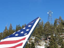 USA-Flagge und Mobilfunkmast