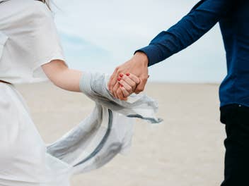 Ein Mann und eine Frau halten sich an der Hand.