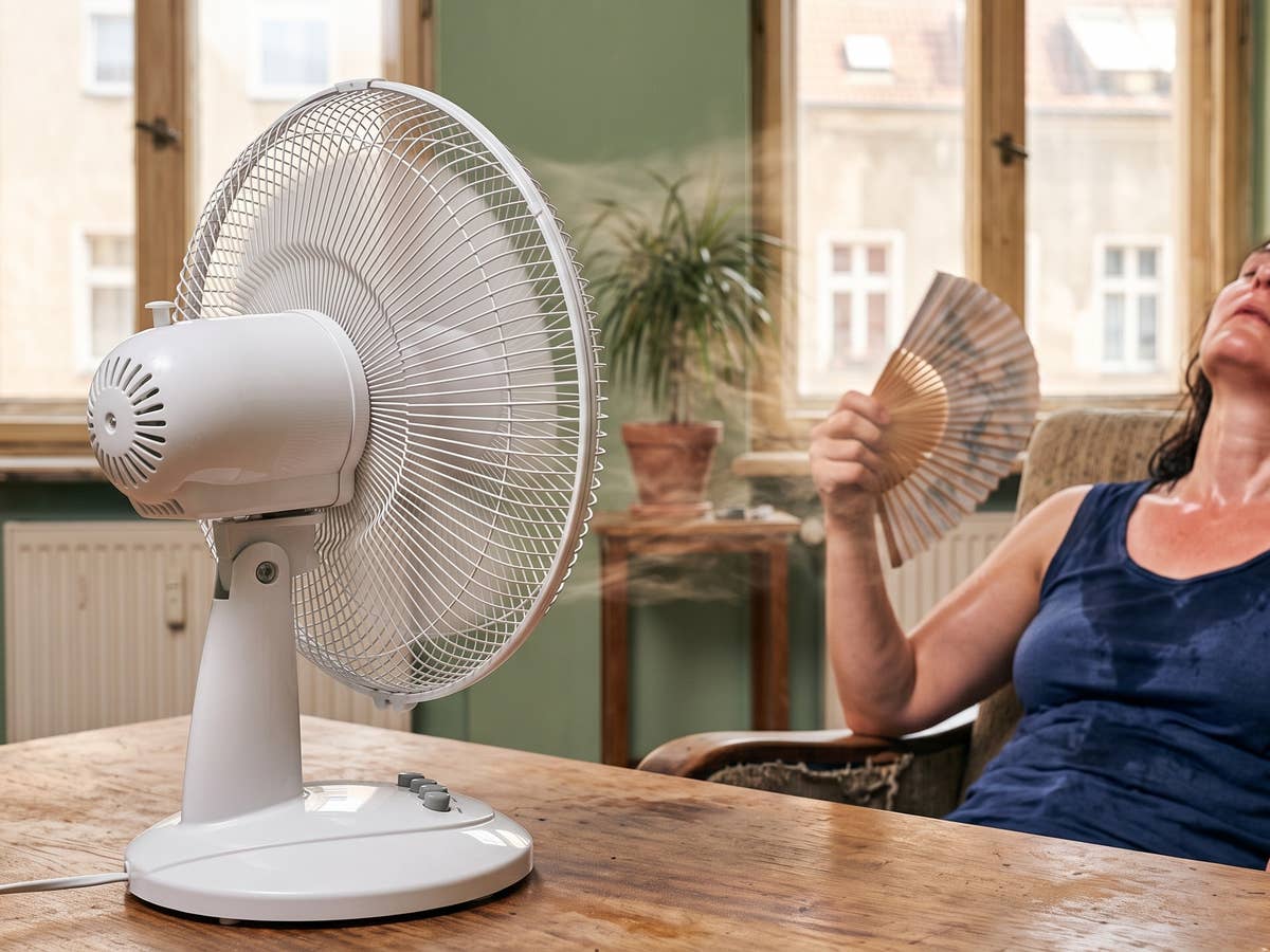 Eine Frau sitzt vor einem Ventilator