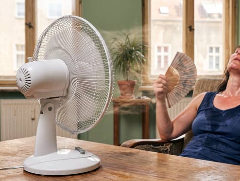 Und plötzlich heizt der Ventilator, statt zu kühlen – ab wann du ihn abschalten solltest Eine Frau sitzt vor einem Ventilator