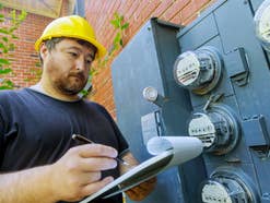 Elektriker vor einem Kasten mit Stromzählern