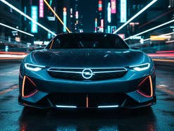 Auto von Opel in der Frontansicht vor dem HIntergrund einer beleuchteten Skyline.