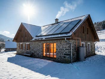 Wohngebäude mit PV-Module im Winter unter Sonnenlicht mit Tank für Flüssigbatterie