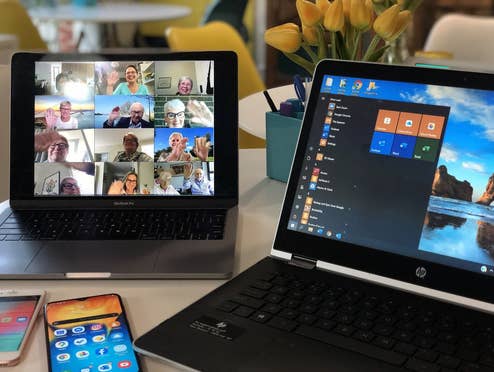 Videokonferenzen im Homeoffice Zwei Laptops und ein zwei Handys in einer Homeoffice-Situation mit einer Videokonferenz