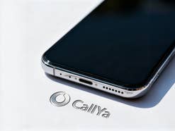 Vodafone-Logo mit CallYa-Schriftzug in Silber auf weißem Hintergrund. Darüber liegt ein Smartphone.