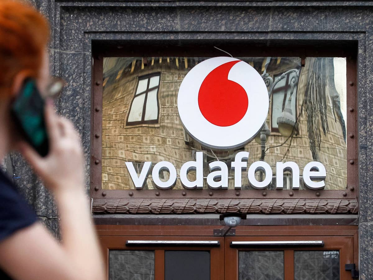 Vodafone CallYa-Aktion mit drei Gratismonaten Vodafone-Logo an einer Wand, links davon eine Person wie sie telefoniert