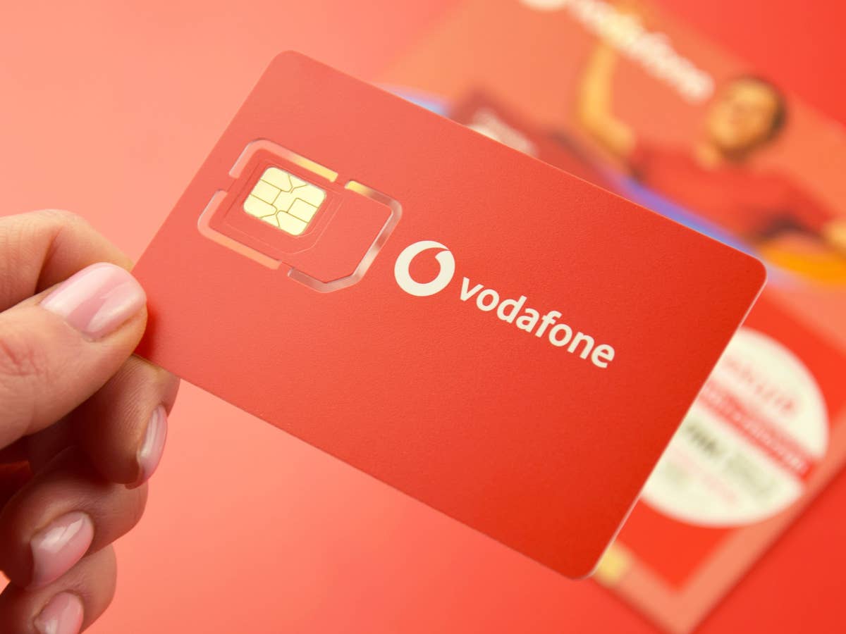 45 Euro Bonus bei Vodafone Eine Vodafone-SIM-Karte wird von einer Hand gehalten