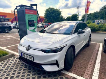 Volkswagen ID.7 steht an einer Ladesäule auf einem Baumarkt-Parkplatz.