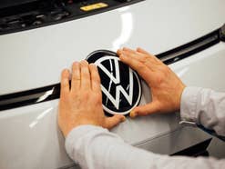 Man bringt Volkswagen-Logo auf der Motorhaube eines Volkswagen ID.3 an.
